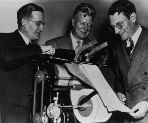 Chester Carlson,  center, demonstrates early xerographic printing technology, which he invented  in 1938.