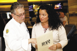 Head chef Jean-Claude Lanchais shows Renaissance General Manager Catherine Stevens the menu at the Hive Living Room + Bar restaurant, one of the newly renovated spaces inside the hotel.