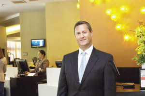 Scott de Savoye stands in the Crowne Plaza”™s lobby, where he said the new color scheme reflects the hotel”™s sophisticated yet warm and inviting ambience.