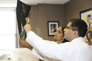 Drs. Neville Bamji and Savreet Sarkaria study an X-ray in their newly opened Scarsdale office.