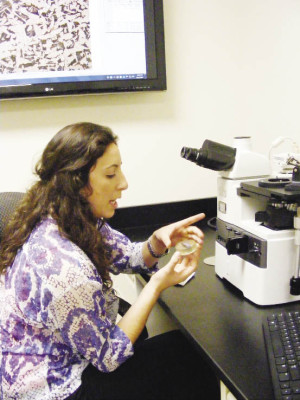 Engineering lab technician Morgan Brown examines steel from a cracked water pipe under a microscope.