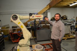 Sam Pagano, a PRS technician, shows off a Kawasaki robot PRS will program.