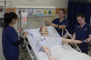 Students at Pace practicing skills on a teched-out mannequin.