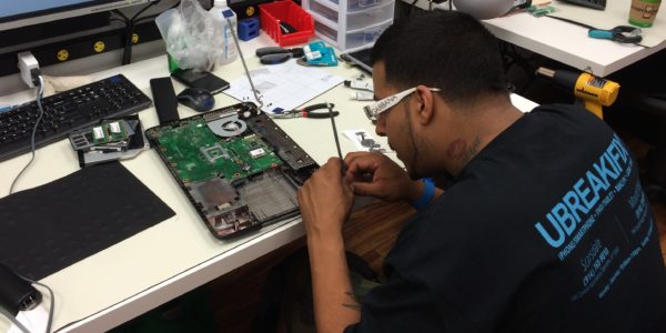 Elliott Sanchez works on a laptop at uBreakiFix. Photo by Leif Skodnick