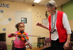 Sister Beth Dowd instructs Kaeleigh Graham Purdy on the violin.