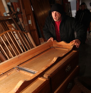 Driver Dave Vitullo wheels in a donated dresser at Furniture Sharehouse. Photo by John Golden