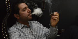 Josh DeSiena smokes in the Doc James Cigar Lounge in Mamaroneck. Photo by Bob Rozycki