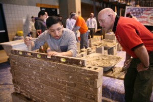 Spring Valley High School junior Kevin Yumbla levels bricks under the watchful eye of Poughkeepsie bricklayer Charles Cooper. Photo by John Golden