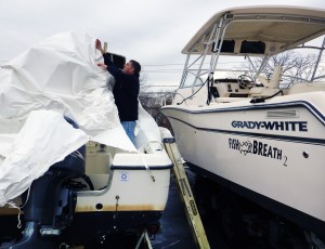 Norm Edwards takes the tarp off a yacht at Rowayton Yacht Club. Photo by Evan Fallor