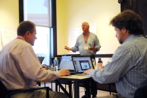 Team SlipShare's Paul Norton, center, speaks as teammates Ken Rist, left, and Darrell DeMakes work during Startup Weekend at the Stamford Innovation Center. Photo by Tyler Sizemore