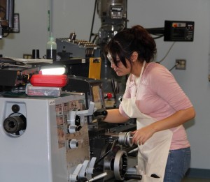 A Housatonic Community College advanced manufacturing program student at a high-tech lathe.