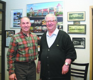 Joe DeRaffele and his father, Phil, stand in front of pictures of diners in their New Rochelle office. Photo by Danielle Brody