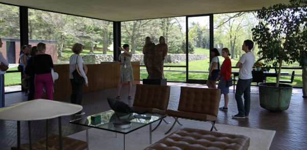 Tour guide Laura Case shows visitors the inside of The Glass House, which has an open floor plan with no walls. Photo by Danielle Brody