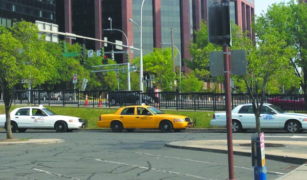 Taxis await customers outside the White Plains train station. Photo by Evan Fallor