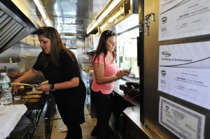 Food truck owners Diana Hall, left, and Darlene Andersen work in the kitchen of their Melt Mobile in Stamford. Photo by Jason Rearick