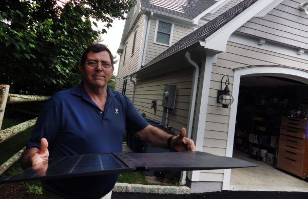 Chris Murphy with a low-profile solar shingle like those on his home. Photo by Bill Fallon