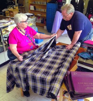 Doreen Browning measures tartan designed in honor of Gen. Douglas MacArthur for the West Point pipe band. Browning and husband Bob, pictured, operate The Kiltmaker”™s Apprentice in Highland.