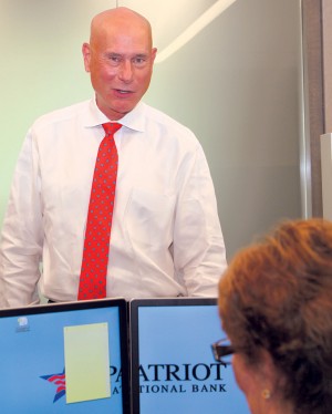 Patriot National Bank CEO Ken Neilson talks with an employee in his Stamford office. Photo by Danielle Brody