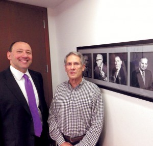 Attorneys Steven Frederick and Marshall Goldberg of law firm Wofsey, Rosen, Kweskin & Kuriansky. The black-and-white photos are firm founders, absent the original founder, Abraham Wofsey, whose son is pictured in the leftmost photo. Photo by Bill Fallon 