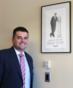 Adam Belardino stands next to a MetLife advertisement that features his grandfather, Gerard Turtora.