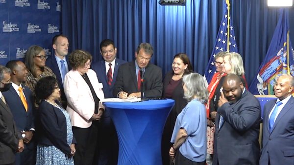 Westchester County Executive George Latimer, surrounded by members of the Board of Legislators, signs abortion access bill the night of June 27.