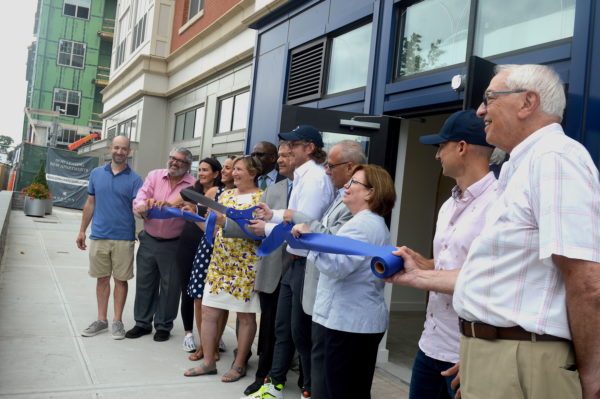 Daybase CEO Joel Steinhaus in center holding scissors during July 25 ribbon-cutting at Daybase in Harrison. Photo by Peter Katz.